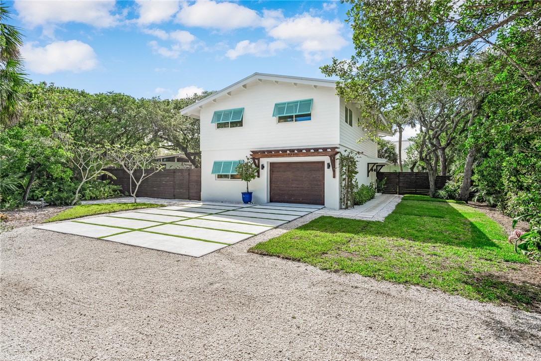 1881 Pebble Path Vero Beach, FL 32963 - Photo 4 of 34 a front view of a house with a yard and garage