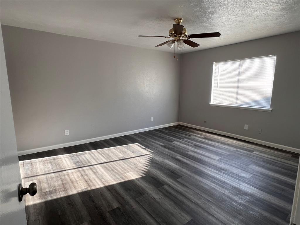8506 Woodside Road Rowlett, TX 75088 - Photo 14 of 27 a view of empty room with wooden floor and fan