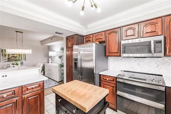 a kitchen with stainless steel appliances a stove a refrigerator and a center island