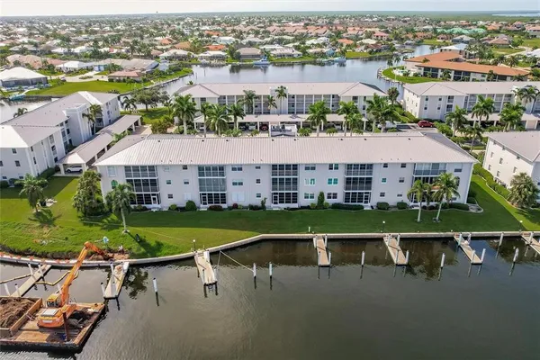 an aerial view of a house with a garden and lake view