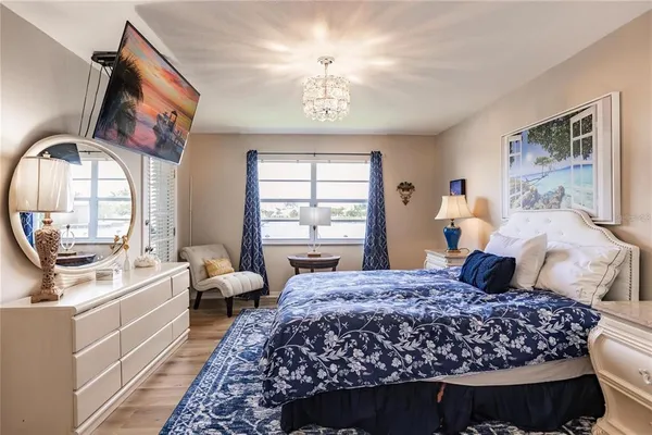 a bedroom with a large bed and a chandelier