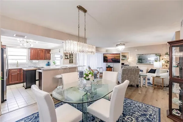 a dining room with furniture a kitchen and chandelier