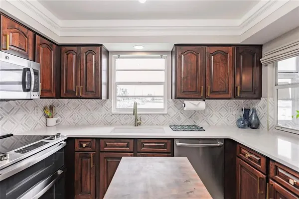 a kitchen with stainless steel appliances granite countertop a sink stove and cabinets
