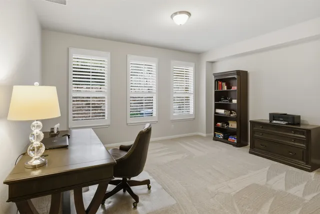 a view of a workspace with furniture and a window