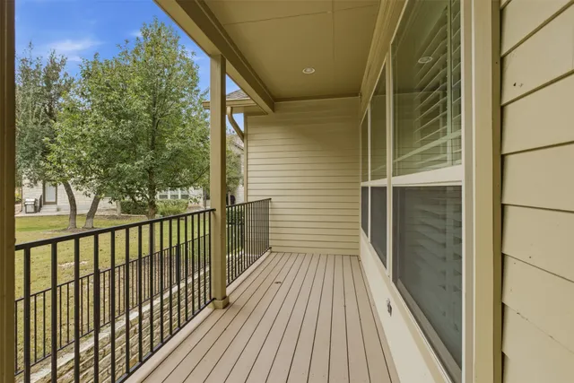 a view of a balcony with wooden floor and fence