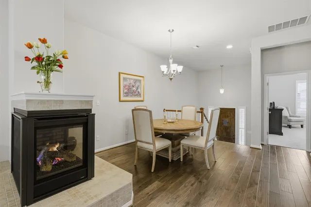 a dining room with furniture a chandelier and wooden floor