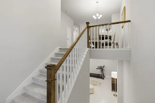 a view of staircase with railing and white walls