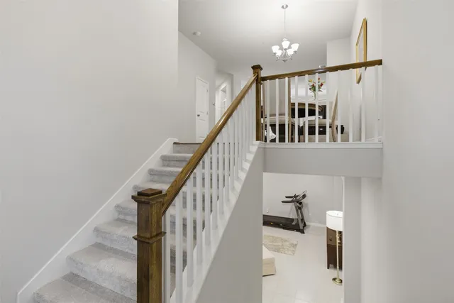 a view of staircase with railing and white walls