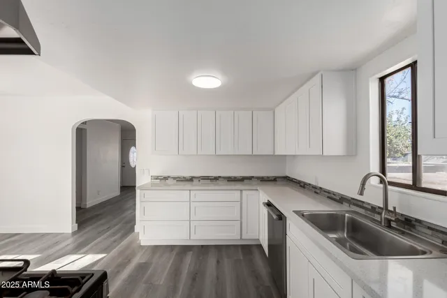 a kitchen with a sink a stove and cabinets