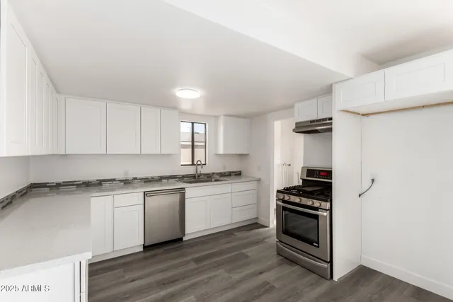 a kitchen with granite countertop a stove and a sink