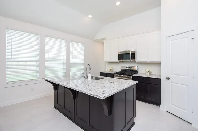 a kitchen with a sink a stove and cabinets