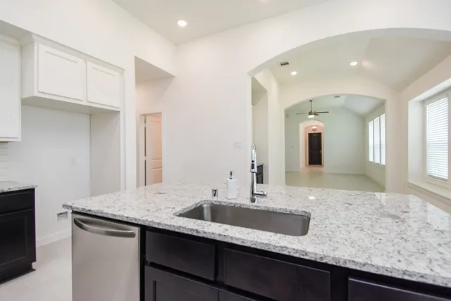 a kitchen with granite countertop a stove and a sink