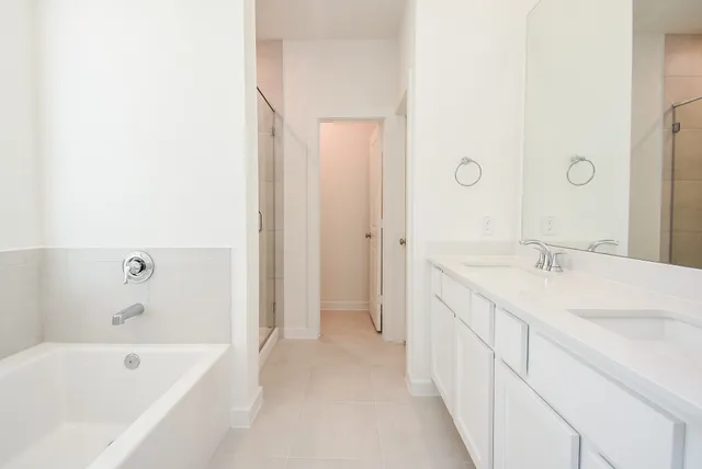 a bathroom with a tub sink and mirror