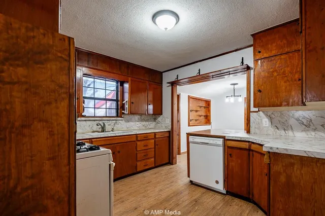 a kitchen with granite countertop a sink and cabinets