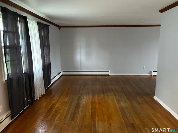 a view of a room with wooden floor