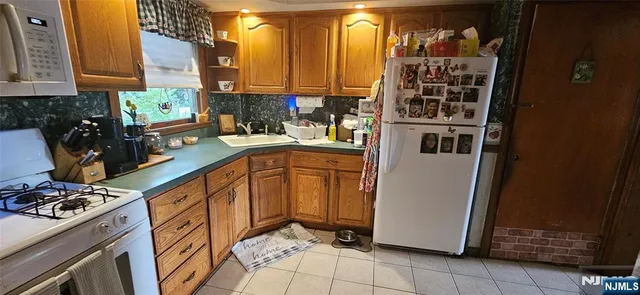 a kitchen with stainless steel appliances a refrigerator a sink a stove and cabinets