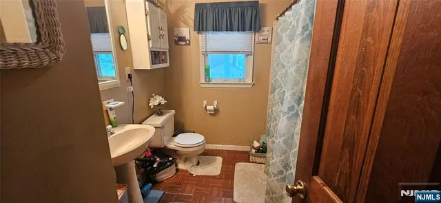 a bathroom with a toilet a sink and a shower curtain