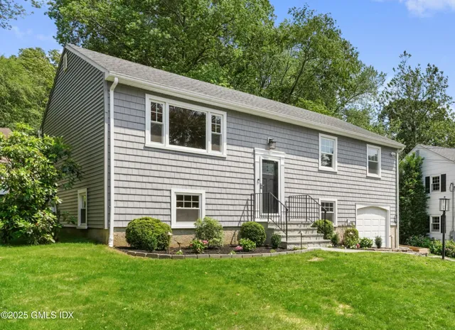 a front view of a house with a garden