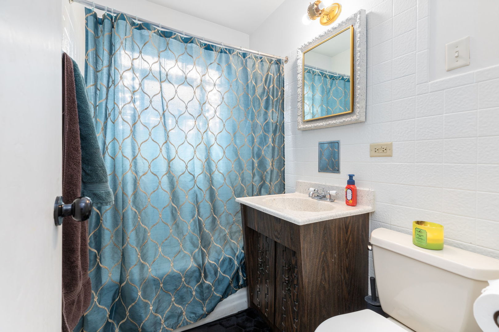 4719 Butterfield Road Hillside, IL 60162 - Photo 7 of 15 a bathroom with a sink a toilet and shower curtain