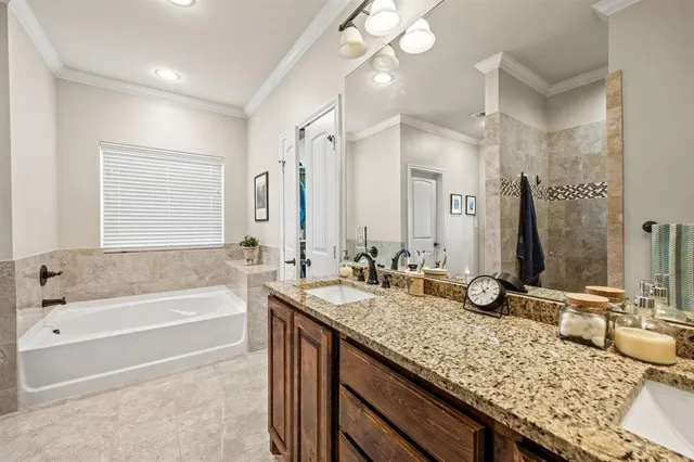a bathroom with a granite countertop bathtub sink vanity and mirror