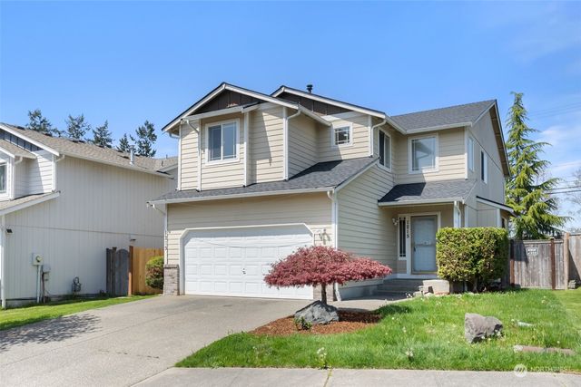 a front view of a house with a yard and garage