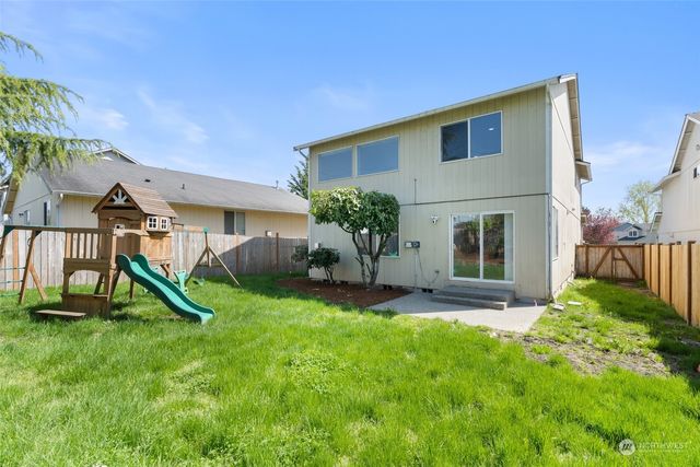 a view of a house with a yard and a park