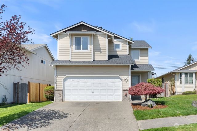 a front view of a house with a garden and plants