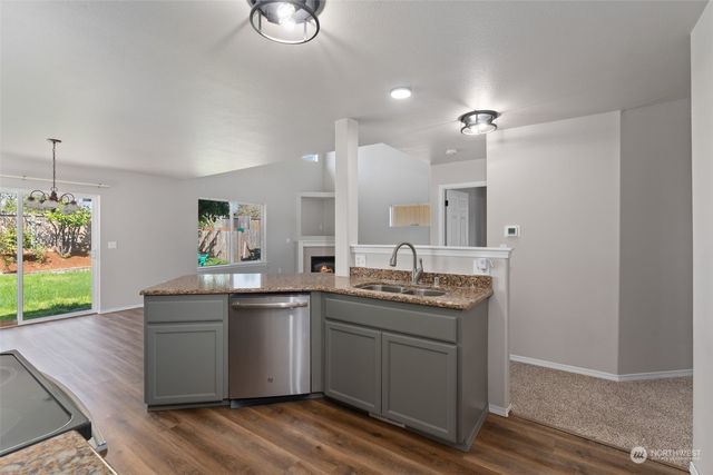 a kitchen with a sink cabinets and wooden floor