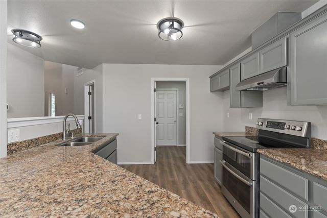 a kitchen with stainless steel appliances granite countertop a sink stove and refrigerator