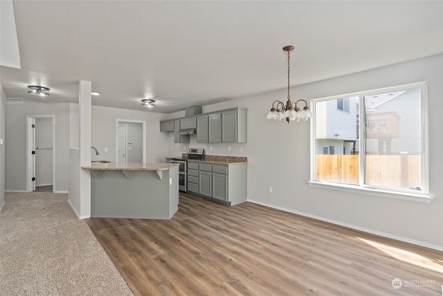 a open kitchen with white cabinets and wooden floor