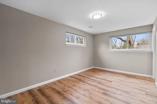 a view of empty room with wooden floor