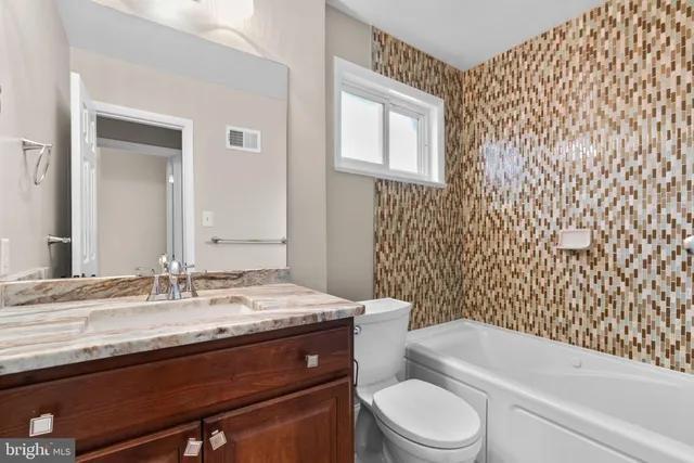 a bathroom with a granite countertop toilet sink and bathtub