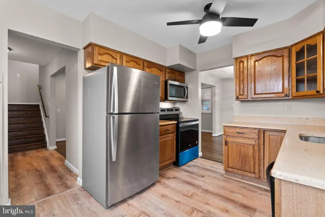 a kitchen with stainless steel appliances granite countertop a refrigerator and a stove top oven