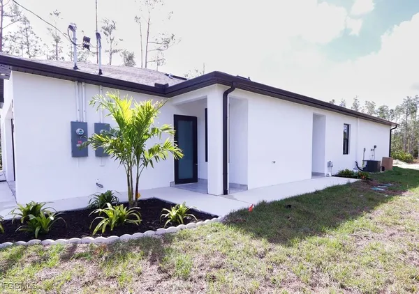 a front view of a house with a yard and a garden