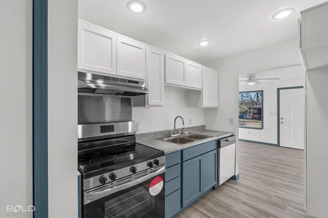 a kitchen with stainless steel appliances a stove a sink and cabinets