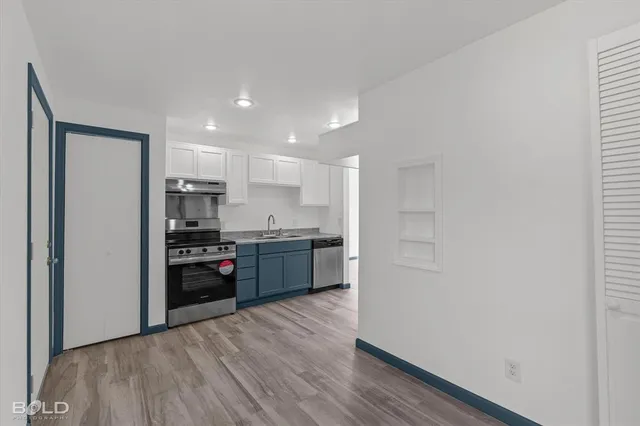 a kitchen with stainless steel appliances granite countertop a refrigerator a stove top oven a sink and dishwasher