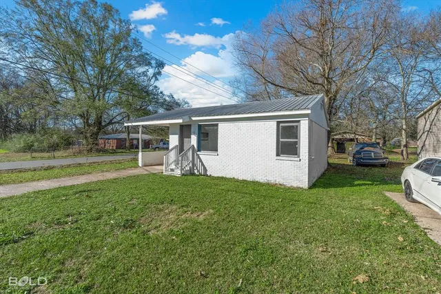 a view of a house with backyard and sitting area