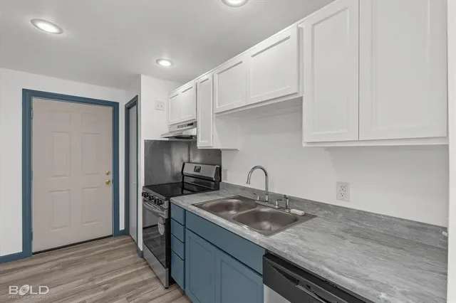 a kitchen with stainless steel appliances granite countertop a sink stove and cabinets