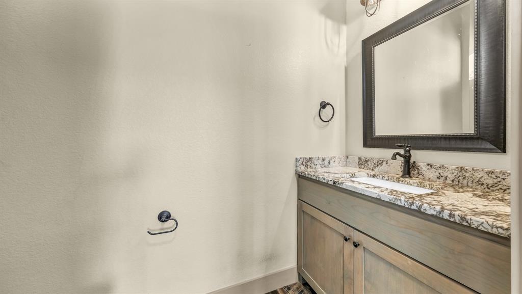 990 Doss Road Millsap, TX 76066 - Photo 21 of 40 a bathroom with a granite countertop sink and a mirror