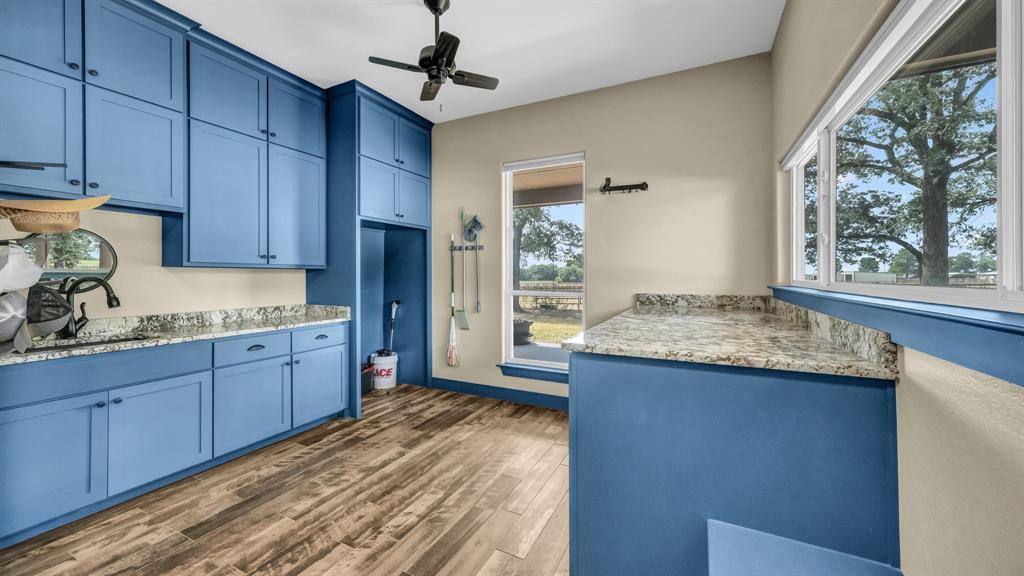 990 Doss Road Millsap, TX 76066 - Photo 22 of 40 a kitchen with granite countertop wooden cabinets and a sink