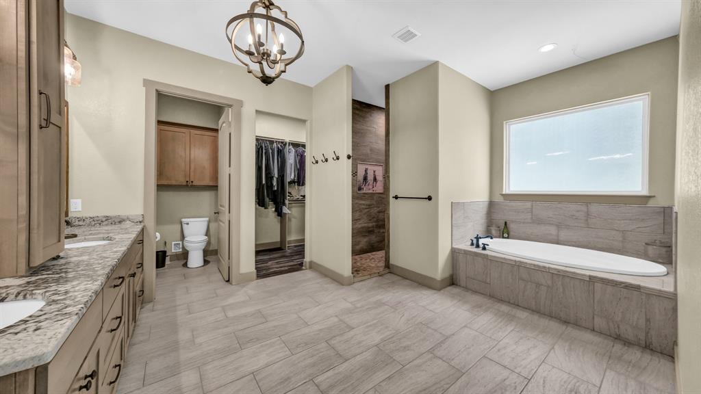990 Doss Road Millsap, TX 76066 - Photo 24 of 40 a bathroom with a tub a double vanity sink and a mirror