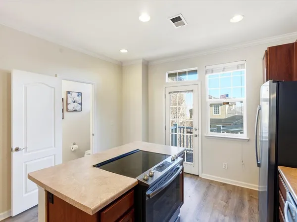 a kitchen with stainless steel appliances a sink a stove a microwave a sink a refrigerator and cabinets