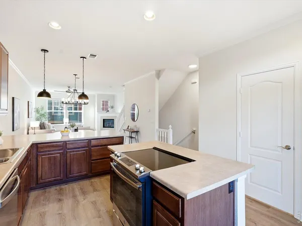 a kitchen with stainless steel appliances kitchen island granite countertop a sink a stove and refrigerator