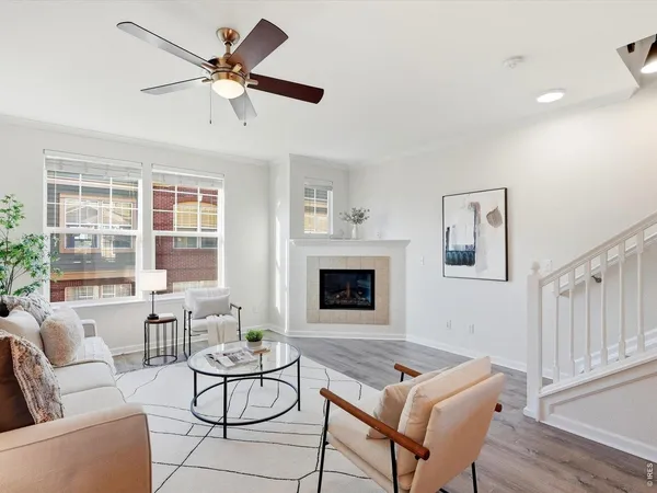 a living room with furniture a fireplace and a floor to ceiling window