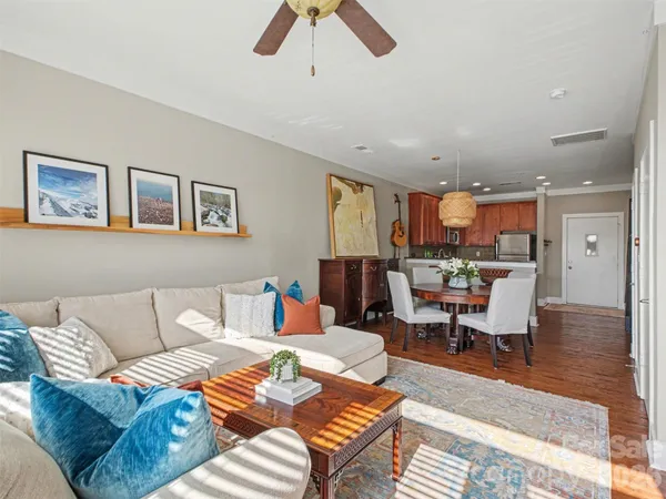 a living room with furniture kitchen view and a window