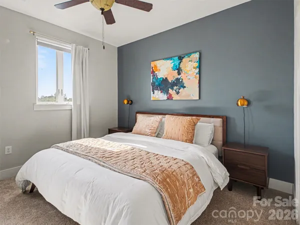 a bedroom with a bed and a painting on the wall