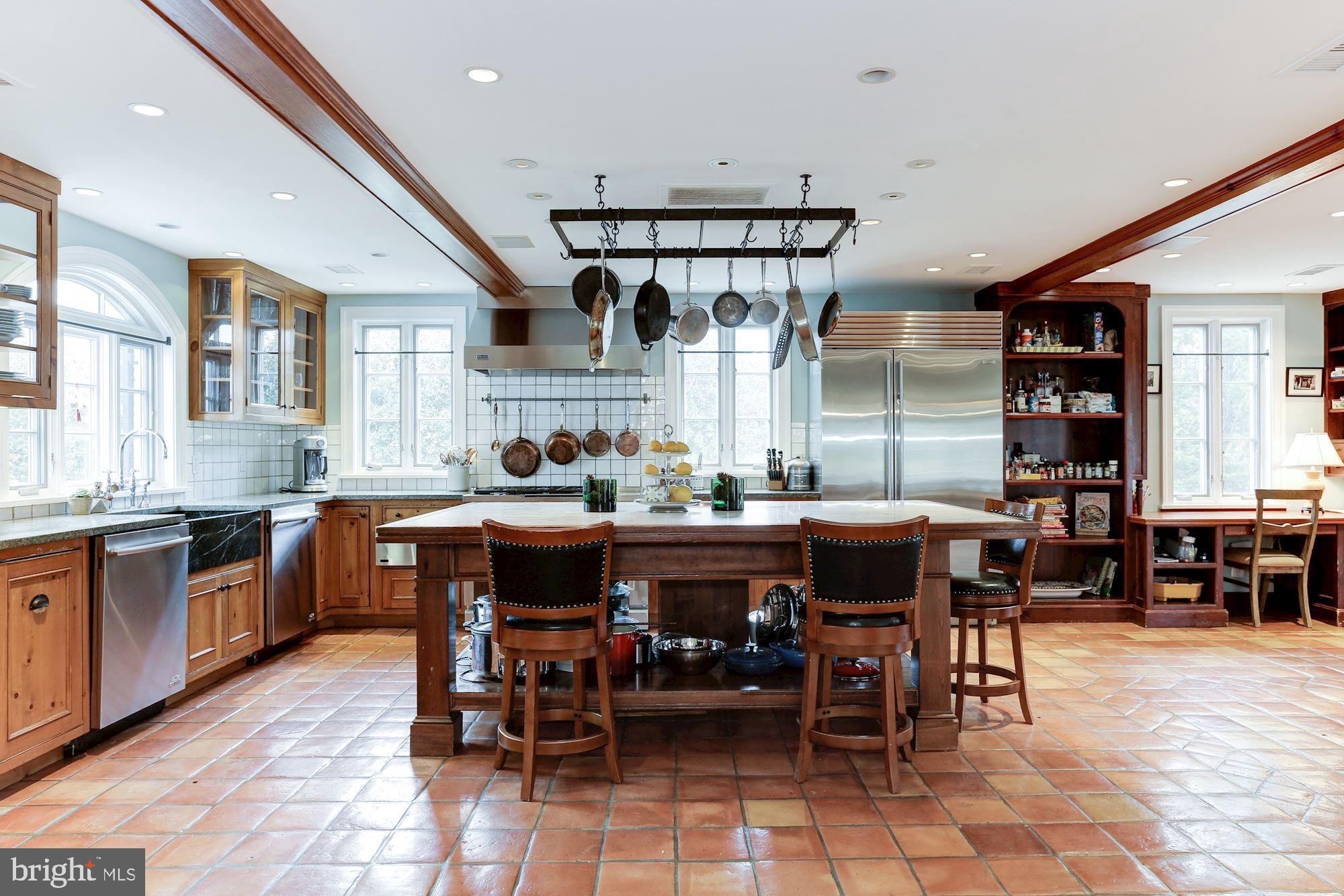 1319 Calder Road McLean, VA 22101 - Photo 11 of 55 a dining hall with stainless steel appliances kitchen island granite countertop a table and chairs in it