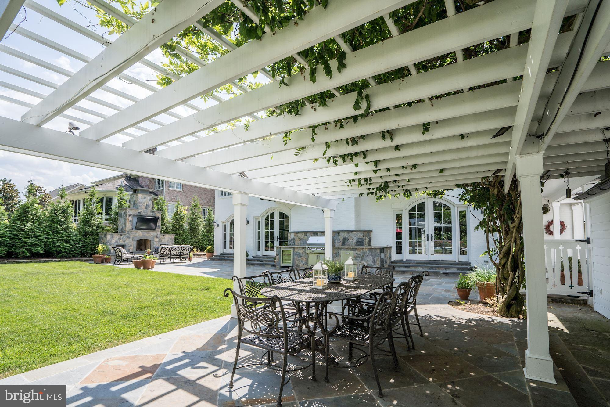 1319 Calder Road McLean, VA 22101 - Photo 50 of 55 a view of a patio with table and chairs potted plants and palm trees