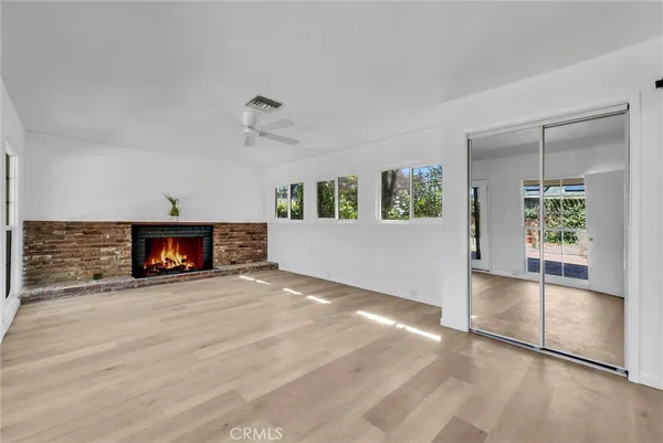 an empty room with windows and fireplace