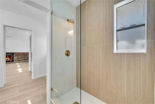 a bathroom with a glass shower door and a window
